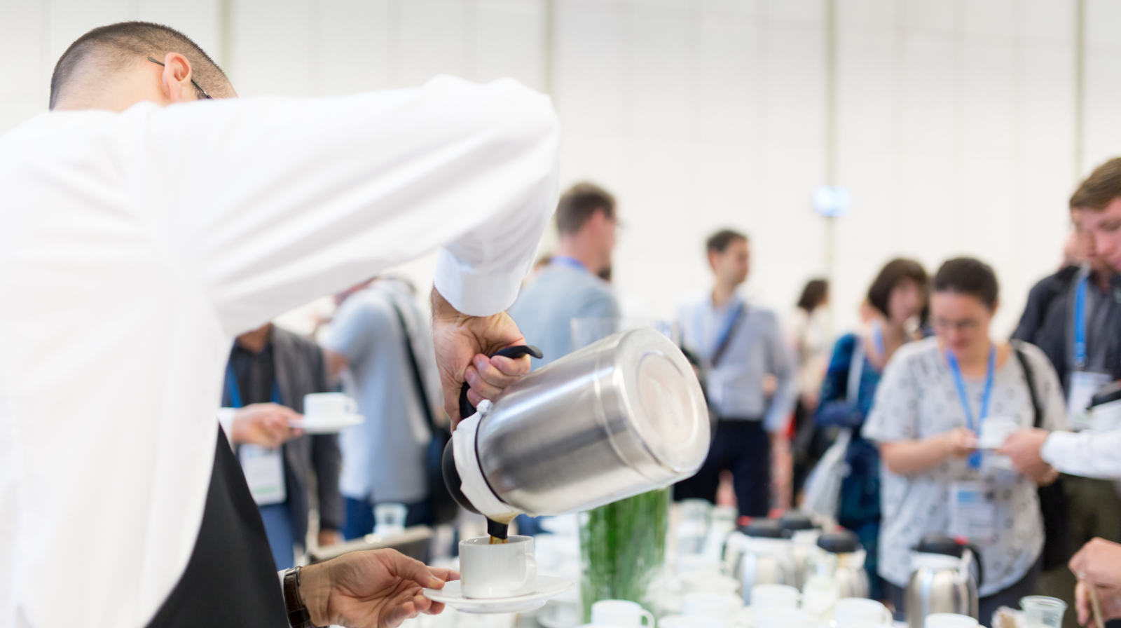 Estratégia de reconhecimento para equipes híbridas durante um coffee break de evento corporativo.